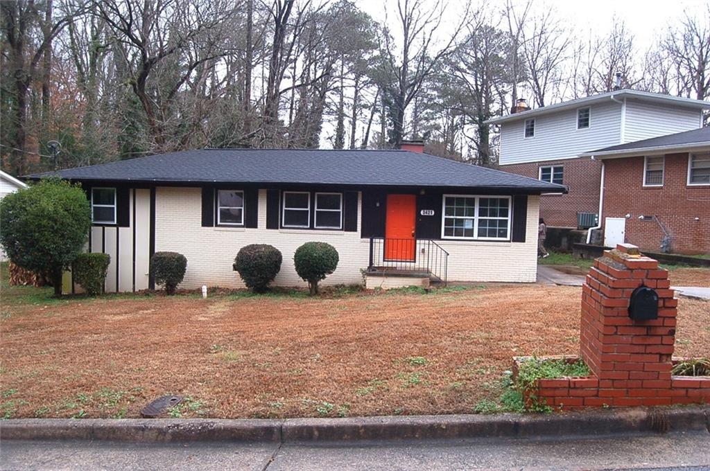 a view of a house with backyard and a tree