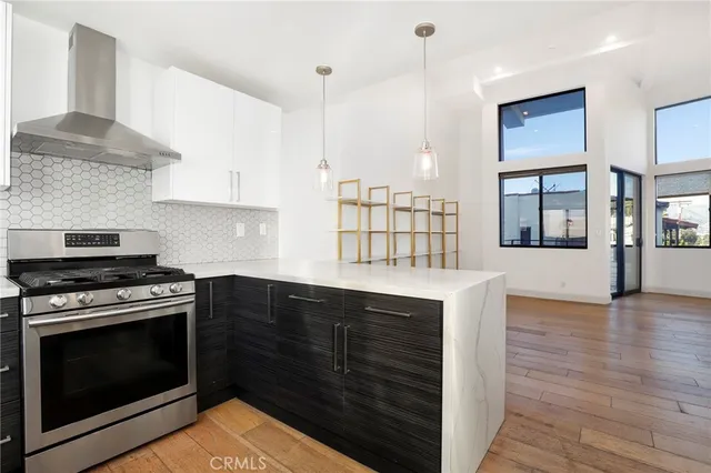 a kitchen with granite countertop a stove a sink and a wooden cabinets