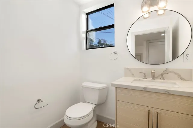 a bathroom with a toilet a sink and mirror
