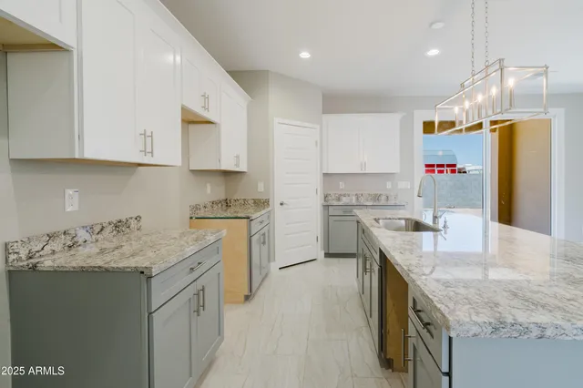 a kitchen with stainless steel appliances granite countertop a sink a stove and a refrigerator