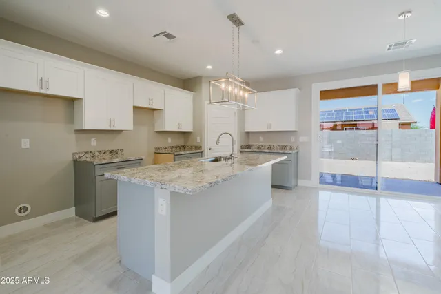 a large kitchen with granite countertop a large counter top stainless steel appliances and cabinets