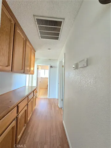 a view of a kitchen with wooden floor and electronic appliances
