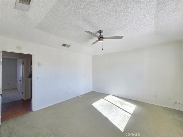an empty room with a ceiling fan and a window