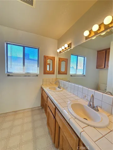 a bathroom with a granite countertop sink a large mirror and a bathtub