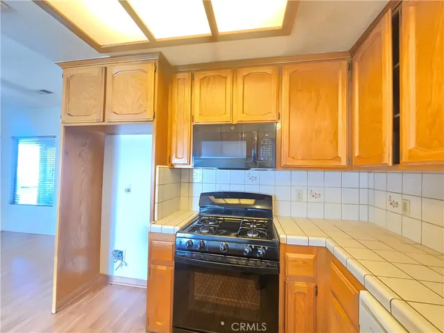a kitchen with a stove top oven cabinets and a wooden floor
