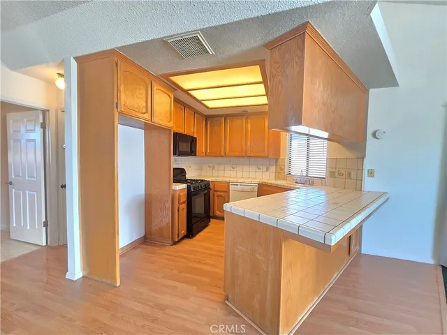 a kitchen with stainless steel appliances granite countertop a refrigerator a sink and a stove