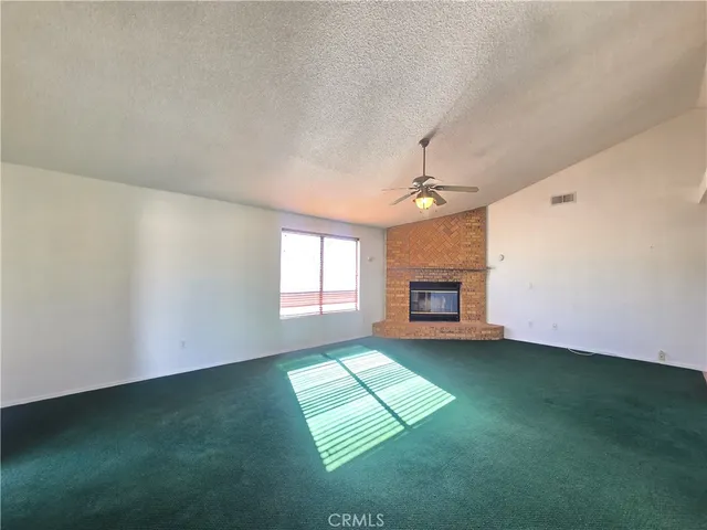 an empty room with windows and fireplace