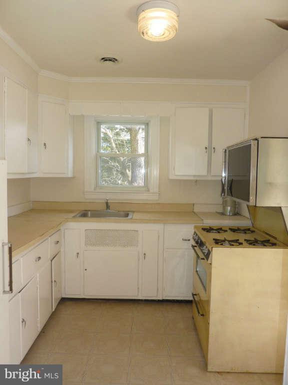 2435 Everton Road Baltimore, MD 21209 - Photo 22 of 28 a kitchen with granite countertop white cabinets and white appliances