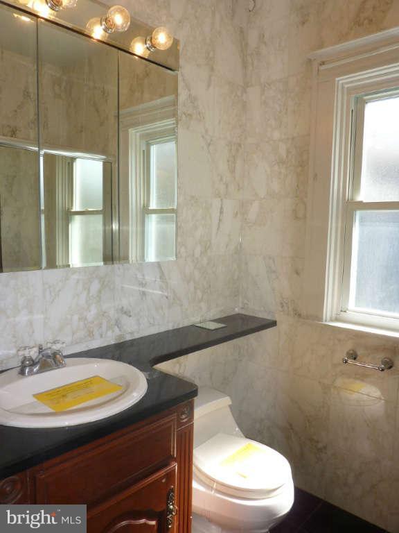2435 Everton Road Baltimore, MD 21209 - Photo 23 of 28 a bathroom with a sink a toilet and mirror