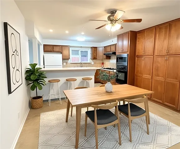 a view of a dining room with furniture and a chandelier fan