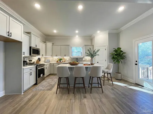 a kitchen with a table chairs a sink dishwasher stove and cabinets with wooden floor
