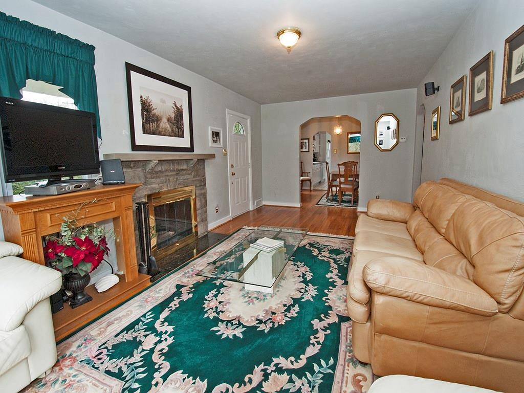 923 McNeilly Road Mt. Lebanon, PA 15226 - Photo 5 of 21 Living Room with hardwood floors, stone fireplace w/glass doors, neutral wall colors. Arched opening leads to the Dining Room offering a nice flow for entertaining.