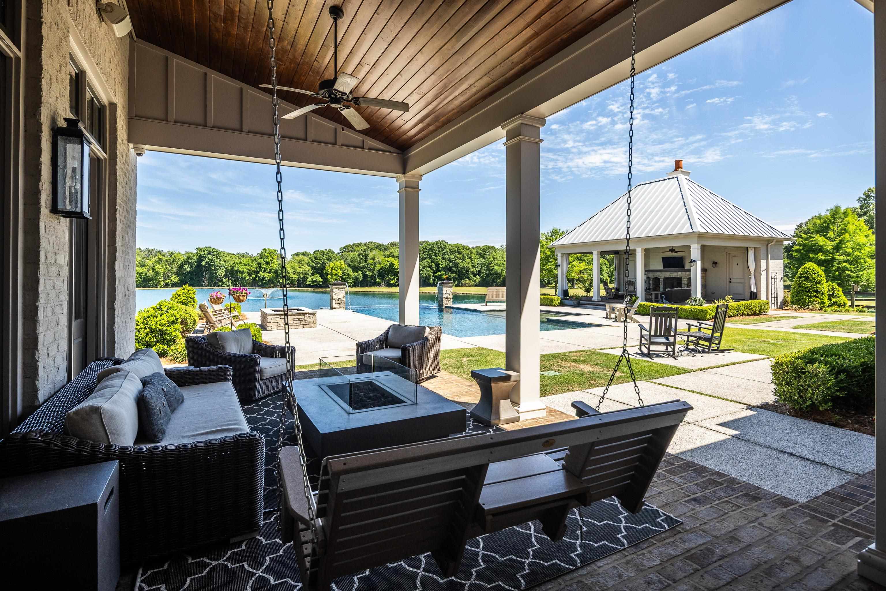 770 Ballard Road Piperton, TN 38017 - Photo 33 of 40 a view of a patio with couches chairs dining table and chairs under an umbrella