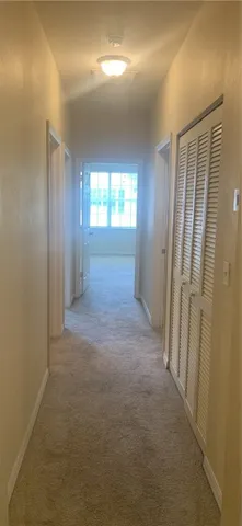 a view of hallway with an empty room and windows