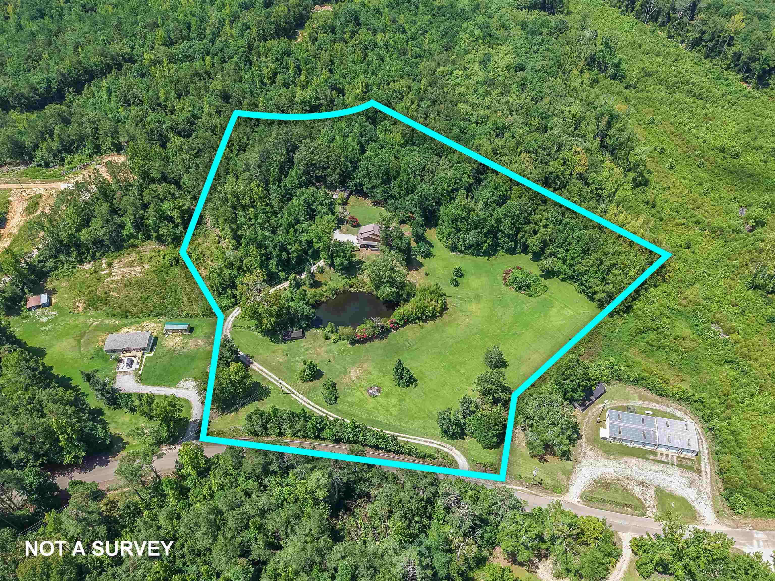 2380 Dunaway Road Selmer, TN 38375 - Photo 2 of 39 Expansive property featuring a private pond, open green spaces, mature tree cover, and a winding driveway