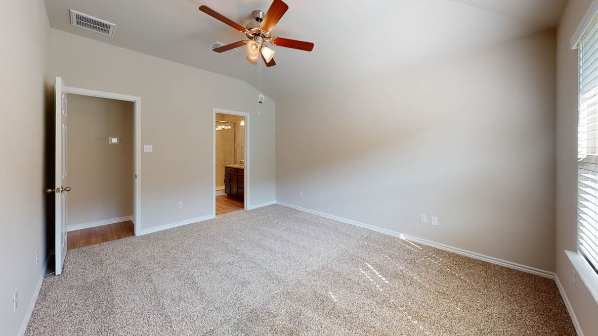 429 Creekfall Road Burnet, TX 78611 - Photo 17 of 28 A quiet retreat with plush carpeting and vaulted ceilings, leading to a private bathroom.