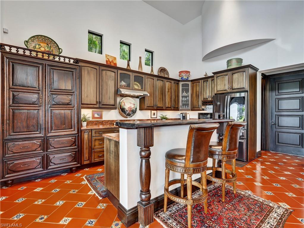 2535 Tarpon Road Naples, FL 34102 - Photo 13 of 50 Formal dining space featuring terracotta tile flooring and a grand chandelier