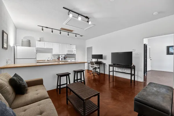 a living room with furniture kitchen view and a flat screen tv