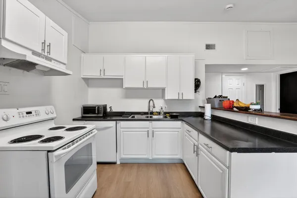 a kitchen with stainless steel appliances a white stove top oven sink and cabinets