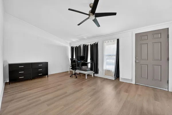 an empty room with wooden floor and windows