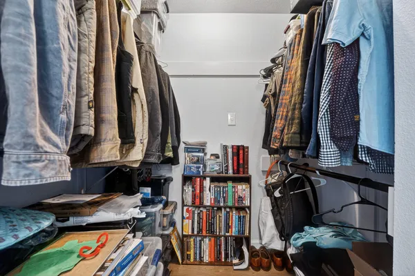 a view of walk in closet with clothes and shoes