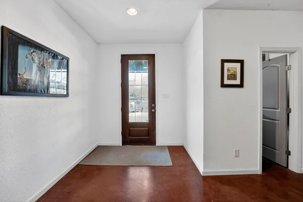 a view of an empty room with window and stairs
