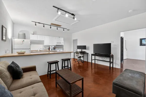 a living room with furniture kitchen view and a flat screen tv