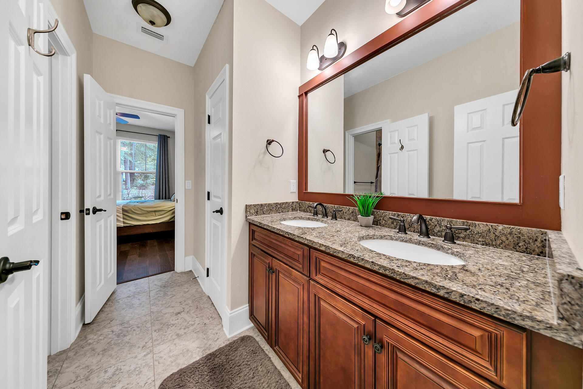 4078 Bond Circle Niceville, FL 32578 - Photo 21 of 37 a en suite bathroom with a granite countertop sink and a mirror