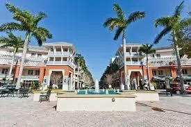 a view of a street with a building and palm trees