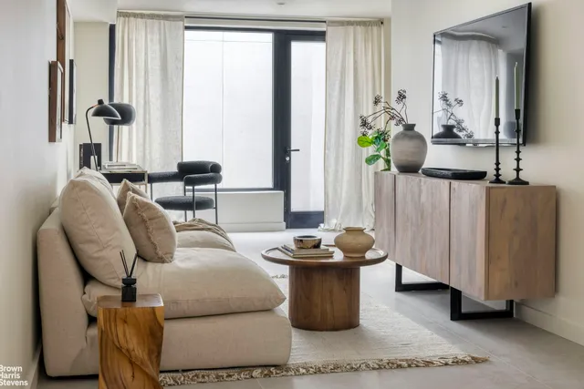 a living room with furniture a large window and potted plants