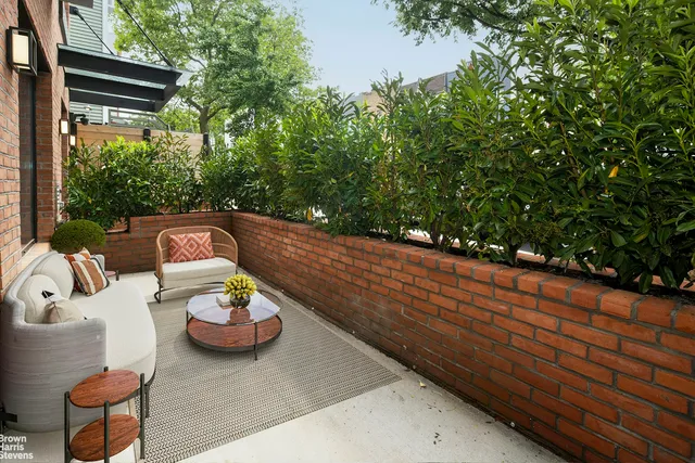 a view of a patio with table and chairs and a wooden fence
