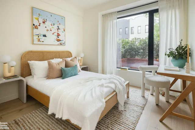 a spacious bedroom with a bed and a large window