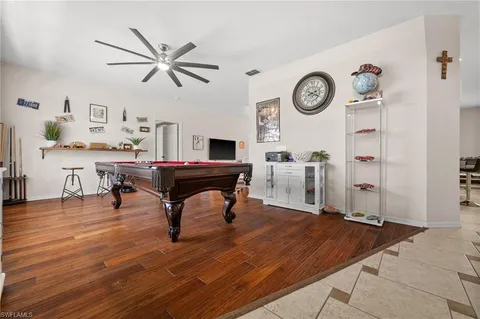 a room with pool table and wooden floor