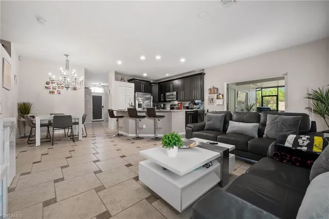 a living room with furniture and a dining table with kitchen view