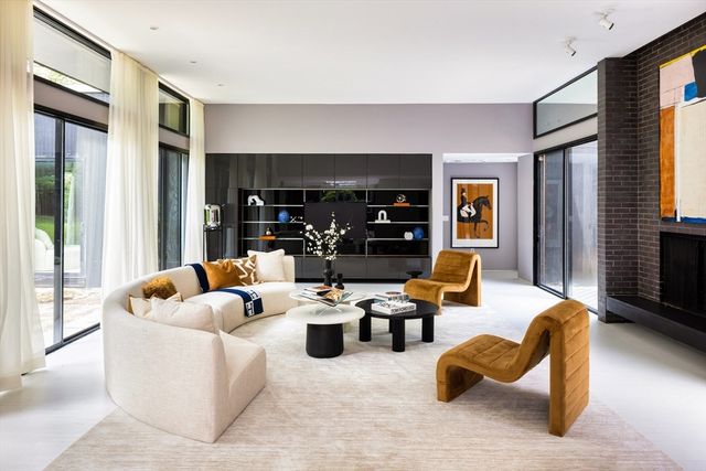 a living room with fireplace furniture and a large window