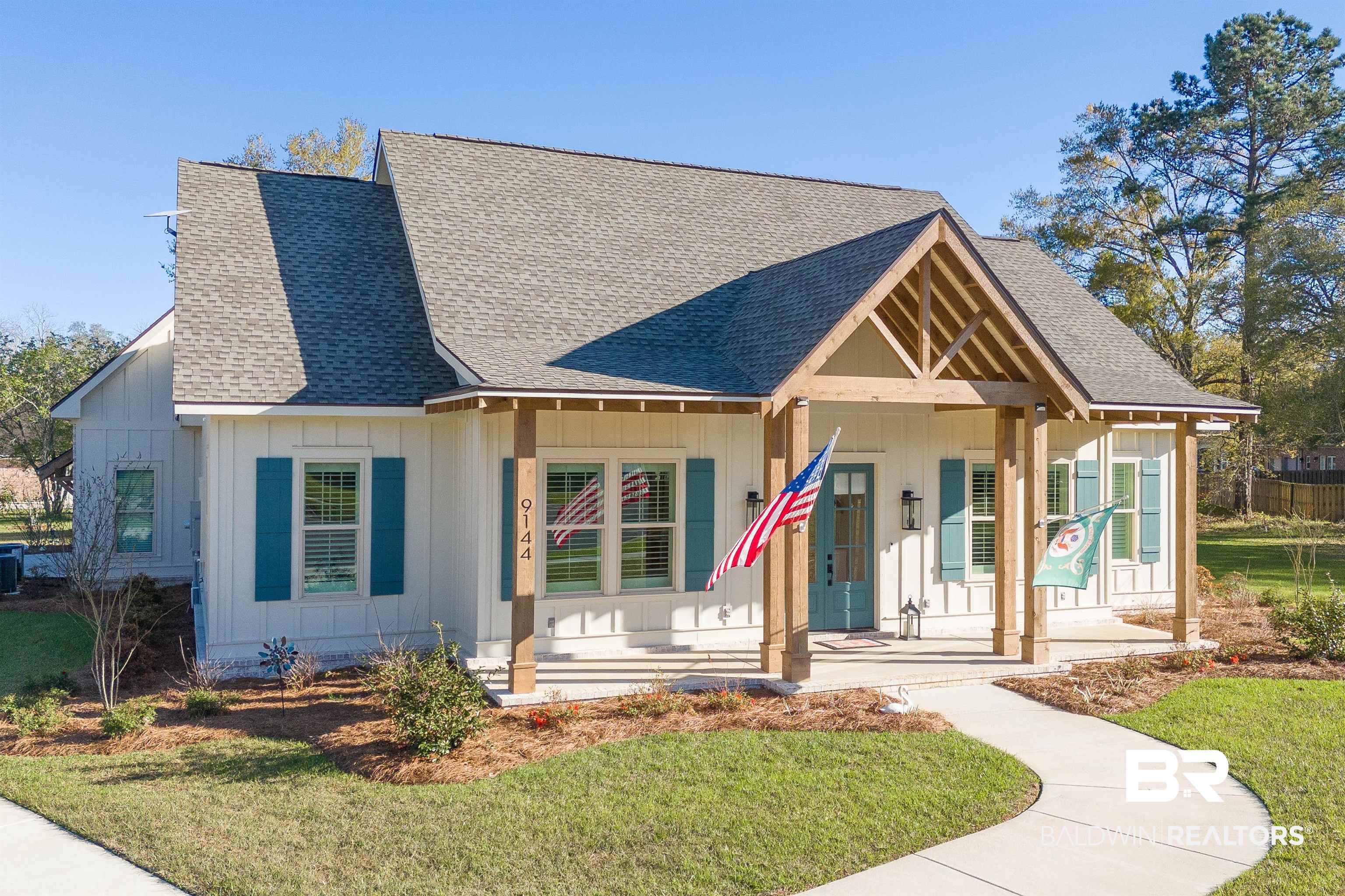 9144 Harvest Ridge Fairhope, AL 36532 - Photo 2 of 58 View of front of property featuring covered porch, a front yard, board and batten siding, and roof with shingles