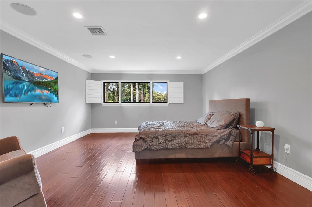 14701 Southwest 63rd Street Southwest Ranches, FL 33330 - Photo 20 of 64 a bedroom with a bed and wooden floor