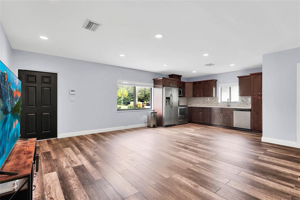 14701 Southwest 63rd Street Southwest Ranches, FL 33330 - Photo 45 of 64 a view of kitchen with stainless steel appliances kitchen island wooden floor and window