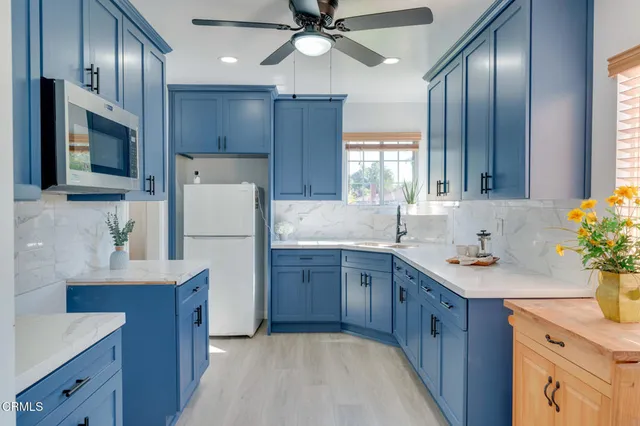 a kitchen with a sink stainless steel appliances and chandelier