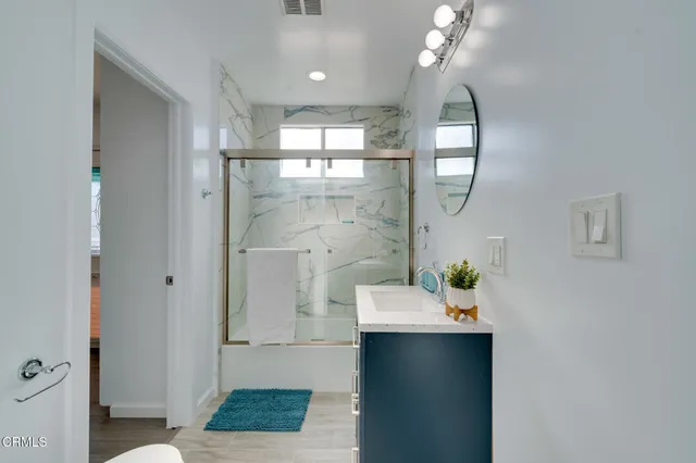 a bathroom with a sink a shower and a mirror