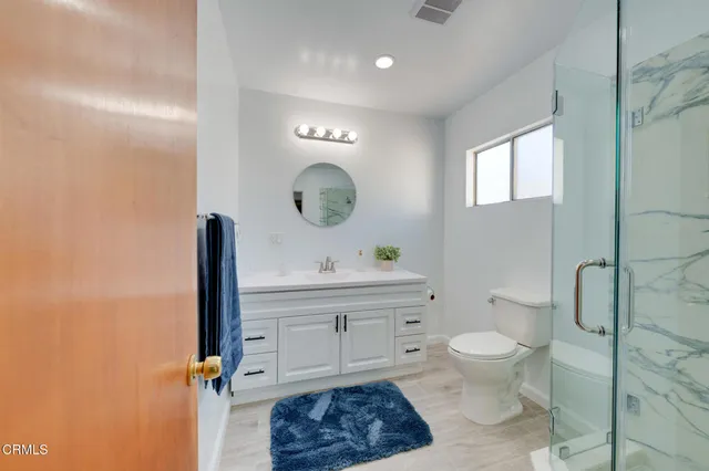a bathroom with a toilet a sink and mirror