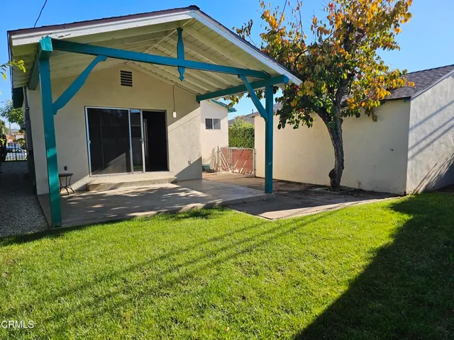 a backyard of a house with table and chairs