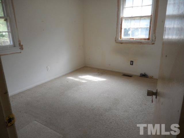 907 Newcombe Road Raleigh, NC 27610 - Photo 5 of 9 an empty room with windows