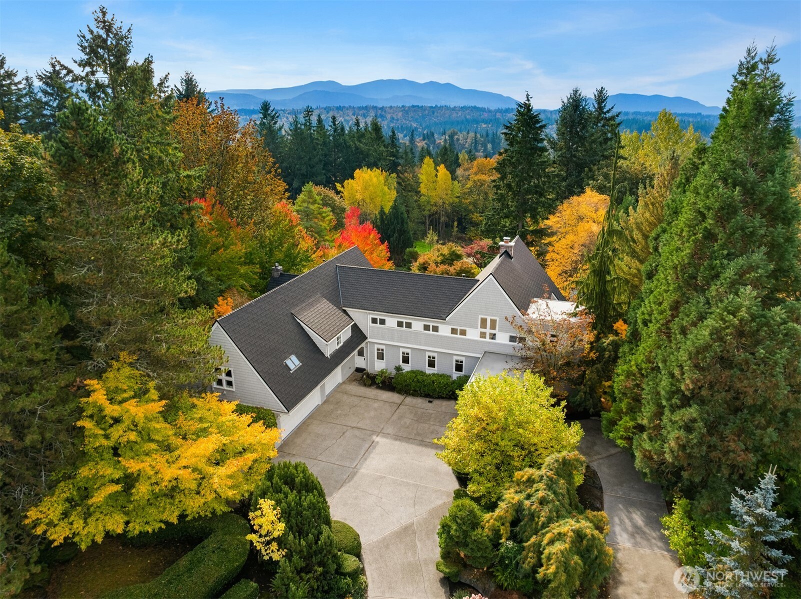 an aerial view of a house with a garden and lake view