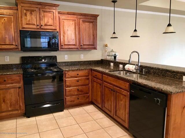 6911 Nick Street Amarillo, TX 79119 - Photo 2 of 6 a kitchen with granite countertop a stove and a sink