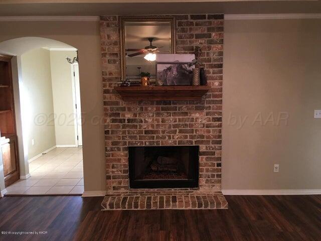 6911 Nick Street Amarillo, TX 79119 - Photo 4 of 6 a living room with a fireplace and a wooden floor