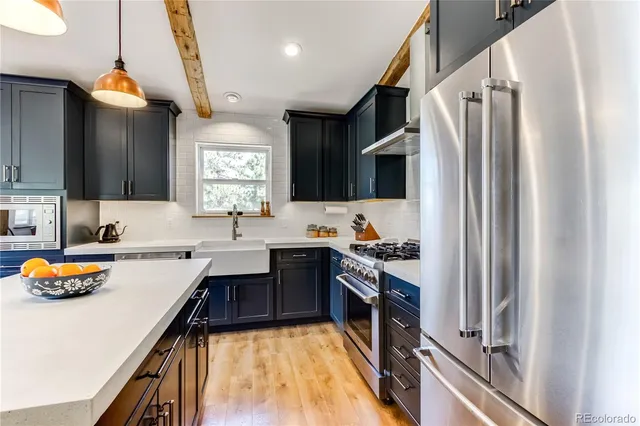 a kitchen with stainless steel appliances a sink stove and refrigerator