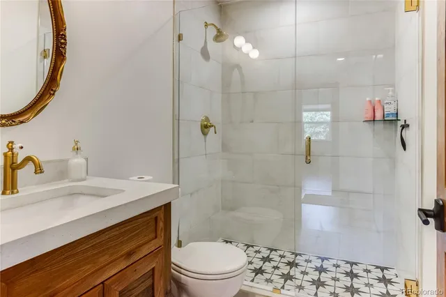 a en suite bathroom with a granite countertop sink and a mirror