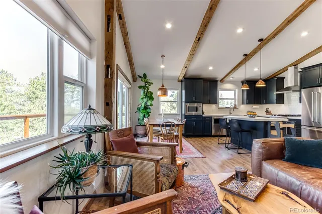 a living room with furniture kitchen and a large window