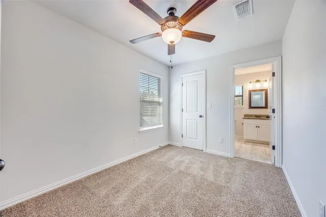 a view of a room with a ceiling fan and a window